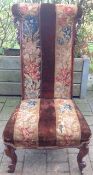 A Victorian mahogany prie-dieu chair with cabriole legs to the front and upholstery with tapestry
