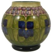 A Moorcroft tube lined Violet vase, by William John Moorcroft the bulbous body with violet