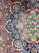 A pair of early 20th century Persian carpets the quartered madder field with central turquoise and