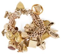 A heavy 9ct gold rose gold double curb link charm bracelet hung with a variety of gold charms