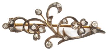 A delicate Edwardian rose diamond set floral scroll brooch formed as a softly curved single