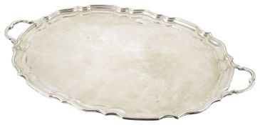 An impressive George V silver twin handle tray, Sheffield 1919of oval pie crust from with two shaped