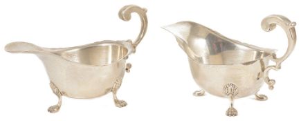 A pair of Mappin & Webb silver sauce boats with scrolled handles, upon shell and paw supports,