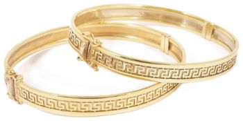 A pair of contemporary matching 9ct gold hinged bangles each with a continual central raised Greek