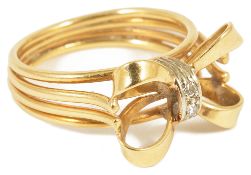 An unusual diamond set 'tied ribbon bow' cocktail ring, circa 1950the yellow metal tied bow with