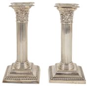 A pair of silver dwarf candlesticks, Birmingham 1908with beaded concave drip trays above