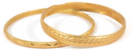 Two Eastern yellow metal bangles, test for high carat goldeach with bright cut decoration (2)approx.