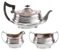 An Edwardian three piece tea service, hallmarked Sheffield 1918the teapot with ribbed body and