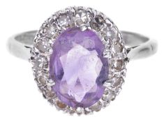 An oval amethyst and diamond set cluster ringthe oval light coloured amethyst set within a small