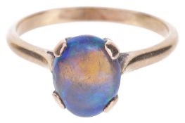 A single stone precious black opal set ringthe oval opal mounted in a yellow metal mount, tests