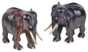 A pair of Indian hardwood elephants, 20th centuryeach standing with bone tusks and eyes, a/f, (2)