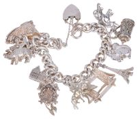A heavy silver curb link charm braceletthe bracelet hung with a variety of charms including an
