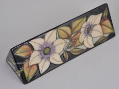 A contemporary Moorcroft pottery triangular shaped promotional stand by Sian Leeper