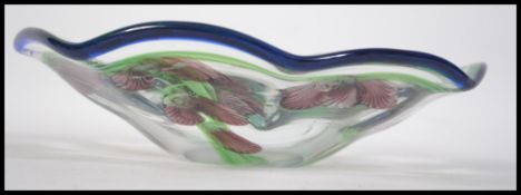 A stunning 20th century studio glass dish being decorated with a continuous sweet pea design