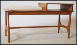 A 1970's retro telephone hall table seat combination in teak having a pad seat with telephone