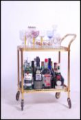 A retro 20th century drinks trolley together with a selection of vintage and retro glasses and a