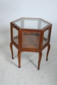 An early 20th century mahogany bijouterie drum table display cabinet. The table being raised on