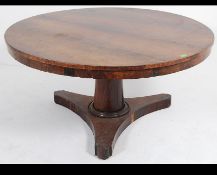 A 19th century Regency rosewood upholstered tilt top breakfast / loo table raised on turned column