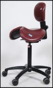 A  20th century retro Salli Saddle dentist / machinists chair having unusual red leather saddle
