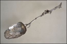 A Victorian silver ( tested )large berry spoon having twig handle adorned with flower head. The