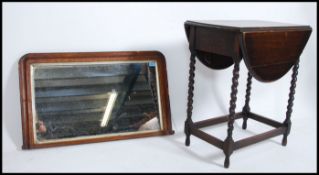 An early 20th century oak gate leg drop leaf table raised on barley twist supports together with