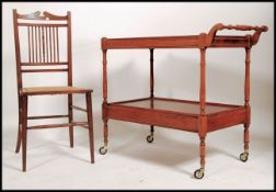 A 20th century 2 tier tea trolley having a slide out top tier and drawers to the lower tierbeing