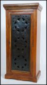 A 20th century hardwood and cast iron lattice door side cabinet - hall cupboard being raised on a