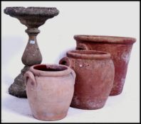 A group of three large vintage terracotta garden pots together with a well weathered reconstituted