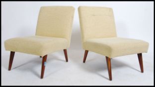 A pair of 1690's retro open armchairs having lozenge shaped teak angular legs supporting yellow