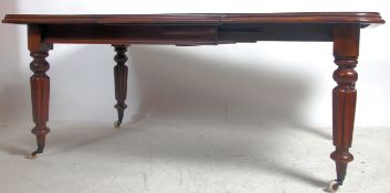 A Victorian mahogany twin leaf wind out dining table raised on reeded tapering supports with castors