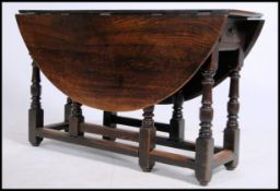 A 19th century country oak gate leg drop leaf dining table raised on turned legs with squared