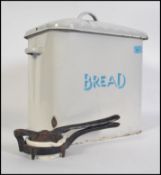 A vintage mid 20th century enamel bread bin of rectangular form having a  scalloped sarcophagus