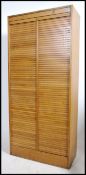A large mid century Industrial oak double tambour office stationary filing cabinet with twin roll