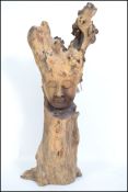 A large vintage 20th century driftwood sculpture with a finely hand carved face to front, thought to