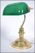 A 20th century bankers desk / work lamp having brass base and upright support below the green