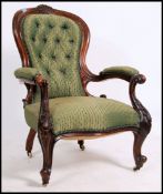A Victorian 19th century mahogany spoon button backed armchair. Raised on shaped legs with