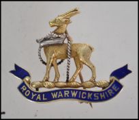 A rare Royal Warwickshire 14ct gold and enamel badge dating to the mid century having roll clasp pin