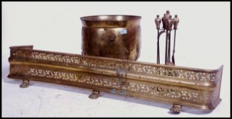 A late 19th century brass fire fender together with a lidded Art's and Craft's coal scuttle.