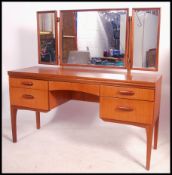 A 1970's retro teak wood dressing table raised on squared legs with drawers flanking central
