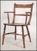 A 19th century beech and elm oxford bar back windsor chair being raised on turned supports with