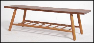 A mid 20th century teak top coffee table having a lower spindle magazine rack. with rectangular
