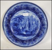 A 19th century large flo blue charger, the wide rim being decorated in high relief, the centre