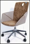 A contemporary suede and faux leather office swivel chair raised on a polished steel swivel base