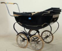 A vintage mid century black metal and canvas covered childs dolls pram by Swan. Wheels and brake