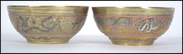 A pair of early 20th century brass Chinese bowls having inlaid silver and copper decoration having