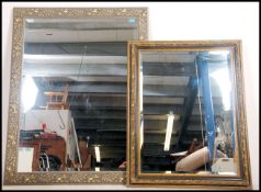 Two contemporary large framed mirrors the frames having  a gilt finish decoration with central