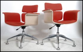 A pair of contemporary retro style swivel desk office chairs raised on polished steel bases with