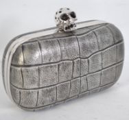 An Alexander McQueen faux crocodile faux leather clutch bag with skull detail clasp fastening,