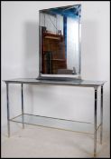 An art deco style chrome and gold finished glass topped consul table with glass shelf under.