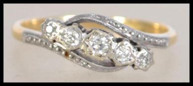 An 18ct gold platinum and diamond 5 stone ring in a cross over design. The diamonds approx 20pnts.